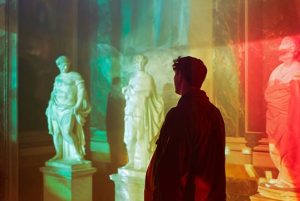 A man looking at greek statues
