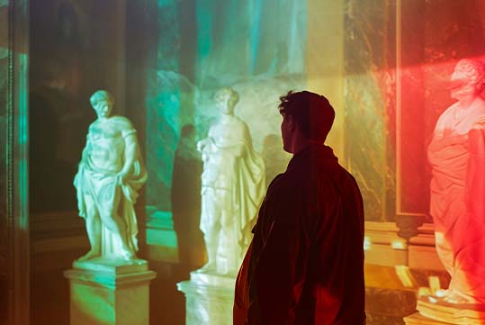 A man looking at greek statues